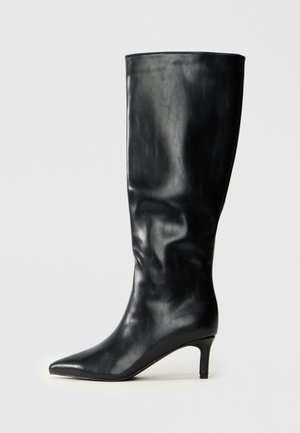 Botte en cuir noir, montant jusqu'au genou, avec un bout pointu et un talon élancé. Texture lisse avec un design ajusté et un minimalisme dans les détails.