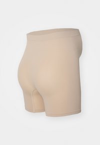 Beige høyt liv sømløse shorts laget av stretchy stoff. Har en jevn tekstur og tettsittende design, egnet for lagdeling under klær.
