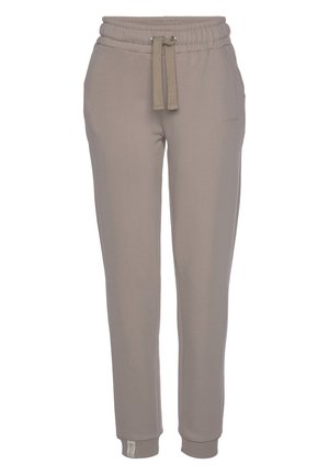 Beige sweatpants featuring an elastic waistband with drawstring, cuffed ankles, and a soft texture. Subtle logo detail on the side.
