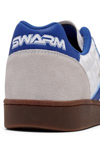 Jasnoszare zamszowe sneakersy z niebieskimi skórzanymi akcentami. Okrągły obcas, gumowa podeszwa i biały napis "SWARM" na tyle.