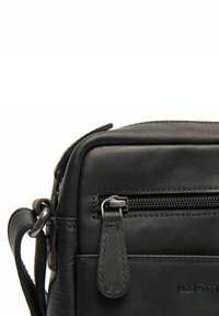 Borsa a tracolla in pelle nera con compartimento principale con zip, finitura testurizzata e tasca frontale piatta con zip metallica e linguetta.