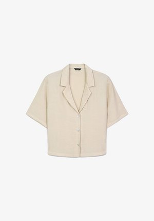 Camicia beige a maniche corte con colletto a punte e tre bottoni sul davanti.