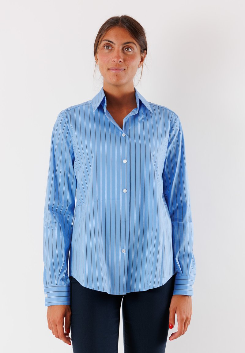 Camicia azzurro chiaro con righe verticali bianche, colletto classico, maniche lunghe e orlo arrotondato, realizzata in tessuto liscio.