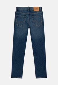 Jeans blu scuri con taglio dritto, dotati di due tasche posteriori e un'etichetta marrone con "Jack & Jones" sulla vita.