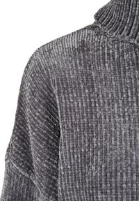 Gros plan d'un pull en tissu velouté gris, épais et côtelé, avec un col roulé.