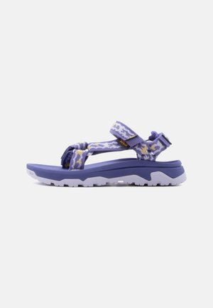 Purple and white patterned adjustable strap sandal with thick sole and rugged tread for outdoor use, side view on white background.