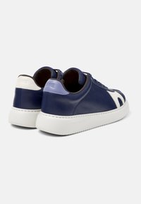 Pari navy blue nahkakengät valkoisilla pohjilla, valkoiset ja laventelinsiniset kantapääpaksut, näkyvät tikkaus ja sivun nauhat.