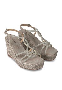 Beige wedge sandals met een gebreid jute platform, suède textuur en metalen banddetails. Verstelbare enkelband voor de juiste pasvorm.