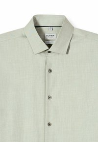 Hellbeiges langärmeliges Hemd mit Knopfleiste, spitzem Kragen und sichtbarem Markenetikett auf der Innenseite des Kragens.