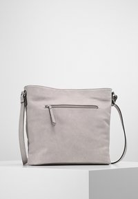 Ljusgrå syntetisk läderväska med justerbar rem. Har en framficka med dragkedja och en slät, matt yta för en ren design.