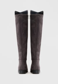 Botas altas de camurça cinza-escuro com saltos baixos em bloco e fechos laterais, vistas de costas sobre um fundo branco.