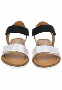 Sandalen met een zwarte stoffen band, een zilveren holografische teenband en bruine gevoerde zolen. Vlakke rubberen zolen voor stabiliteit.