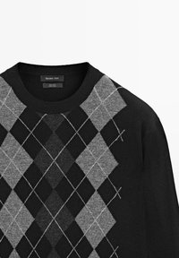 Wollpullover mit schwarzer Basis und grauem Rautenmuster. Der Kragen ist rund, und die Textur wirkt weich und gestrickt.