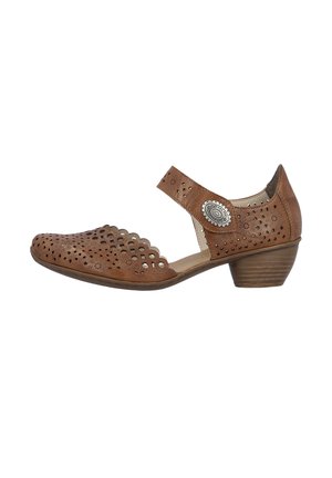 Zapato de piel marrón con tacón medio, con patrones florales perforados, borde del empeine en forma de concha y correa en el tobillo con un botón decorativo plateado.