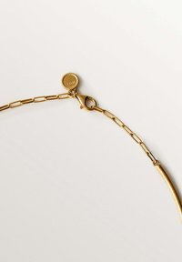 Collar de cadena de oro con eslabones alargados, cierre de langosta y un colgante redondo texturizado grabado con "Milán".