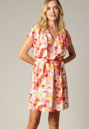 Robe florale avec un décolleté en V, des manches courtes et une ceinture à la taille. Fabriquée en tissu léger avec un motif coloré de fleurs roses, orange et jaunes.