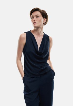Mörkblå ärmlös topp med draperad halsringning, lös passform, gjord av mjukt tyg. Matchas med byxor i samma färg, minimalistisk design.