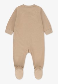 Body bege de algodão com mangas compridas, design com pés e punhos elásticos. Textura suave com decote arredondado e detalhe discreto de costura.