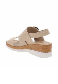 Sandalia beige de cuero con diseño de punta abierta, correa de tobillo ajustable y tacón de cuña de madera. Suela texturizada para un mejor agarre.
