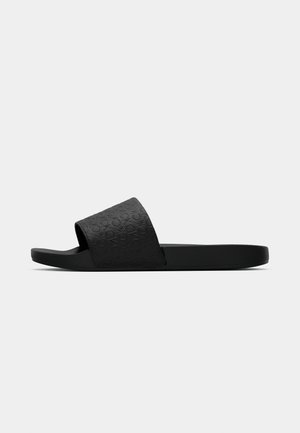Infradito neri con una parte superiore testurizzata caratterizzata da un motivo circolare, suola in gomma piatta e design open toe.
