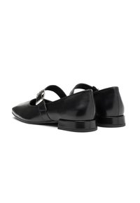 Bailarinas de cuero negro con punta afilada, una correa en el empeine y una hebilla decorativa. Tacón bajo y rectangular, y textura suave.