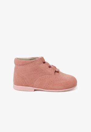 Bottines en suede rose, avec une texture lisse, un bout arrondi, des détails perforés et une semelle rose assortie. Présente un système de fermeture à lacets.