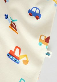 Bavlnená látka s krémovým pozadím a farebnými potlačami vozidiel: áut, vrtuľníkov a stavebných strojov.