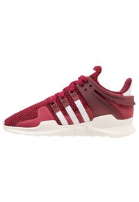 Červená texturovaná pletená sportovní obuv s bílým designem tří pruhů, strukturovanou patní částí a měkkou podrážkou s vlnkovým vzorem.