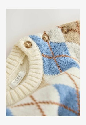 Kreemivärvi, sinise ja beeži salliga kootud kampsun, millel on diagonaalne muster, ribakraed ja kaks ümarat pruuni nuppa õlal.