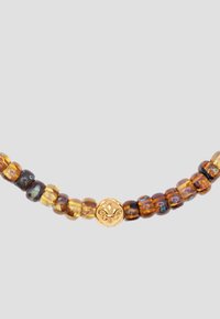 Amber bead necklace with round, varied hues from dark brown to light yellow, featuring a decorative gold clasp with a floral motif.