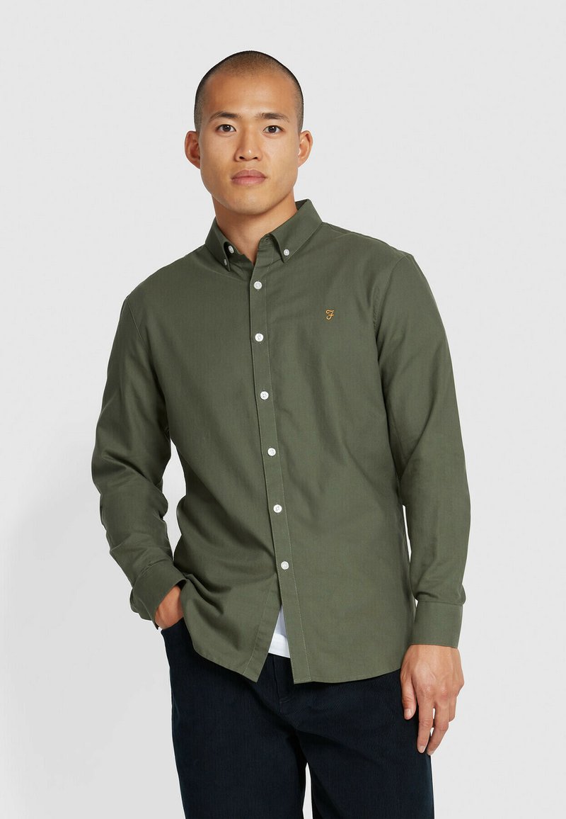 Camicia verde oliva a maniche lunghe in cotone, con colletto e un piccolo logo ricamato sul lato sinistro del petto.