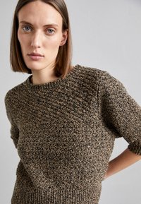 Maglione lavorato a maglia in tonalità marrone e nero terroso con maniche corte e scollatura rotonda; motivo testurizzato su tutta la superficie del tessuto.