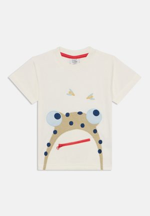 T-shirt in cotone bianco con un design di rana ricamata, occhi blu grandi, macchie nere e una tasca con zip rossa.