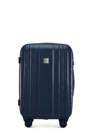 Navy hardshell suitcase with ribbed texture, metallic logo, and four spinner wheels for easy maneuvering. Adjustable side handle included.