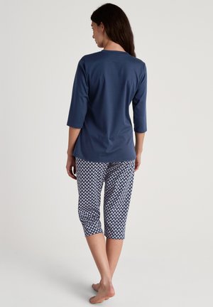 Top blu navy a maniche tre quarti con scollatura rotonda abbinato a pantaloni a Capri con stampa geometrica in bianco e blu.