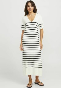 Vestido maxi de manga corta en color crema con rayas horizontales negras, con un corte relajado y una textura de punto suave.