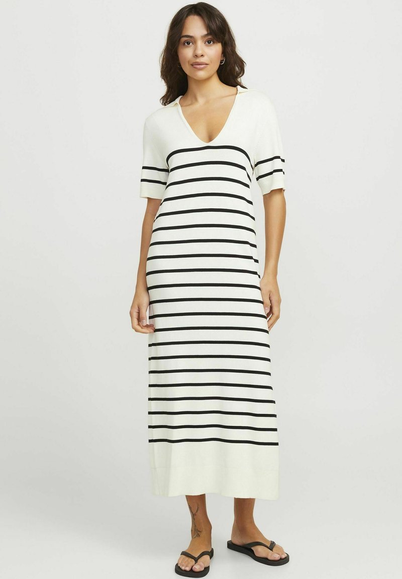 Vestido maxi de manga corta en color crema con rayas horizontales negras, con un corte relajado y una textura de punto suave.