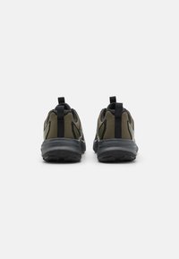 Sportieve schoenen met een ademende olijfgroene mesh bovenkant, zwarte accenten en een duurzame rubberen zool. Voorzien van trekbanden voor gemakkelijke aantrekking.