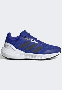Scarpa da atletica viola con tomaia in mesh, design a tre strisce nere, suola leggera e dettagli testurizzati sulla suola.