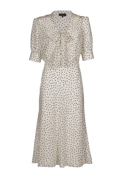 Bézs ruha fekete pöttyökkel, rövid pufó ujjakkal, nyakkendős megoldással és légies szoknyával. Sima anyagból készült, derekánál testhezálló.