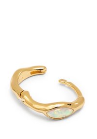 Goldfarbener Metall-Cuff-Armband mit einem glatten, wellenförmigen Design und einem ovalen Opal-Einsatz, der schimmernde Muster aufweist.