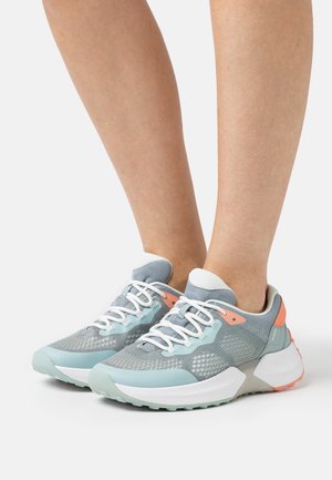 Leichte Sportschuhe mit einem Obermaterial aus mintgrünem und grauem Mesh, weißen Schnürsenkeln, orangefarbenen Akzenten und einer dicken weißen Sohle.