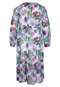 Robe à manches longues à motifs floraux violets, roses et verts sur fond blanc, avec une taille cintrée et une jupe à volants.