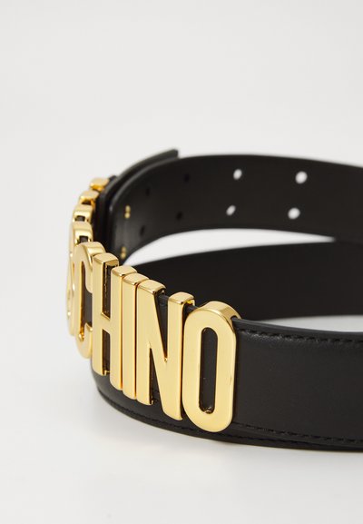 Cinturón de cuero negro con letras doradas grandes y audaces que dicen 'MOSCHINO'. Incluye varios agujeros de ajuste y un acabado suave.