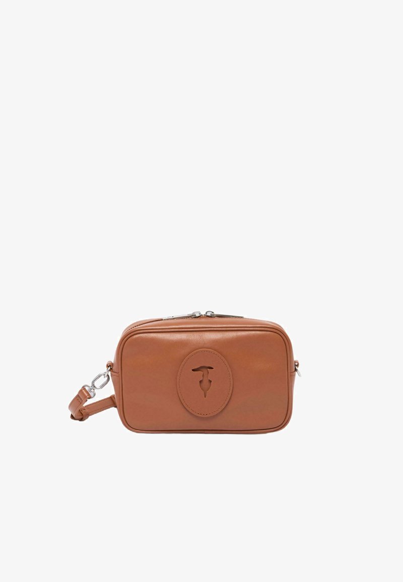 Brown leren rechthoekige tas met een cirkelvormig logo accent aan de voorkant, ritsluiting en een afneembare schouderband om te dragen.