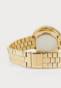 Gold-tone metal watch with a rectangular face, linked bracelet design, and a polished finish. Features a clasp with "Calvin Klein" engraving.