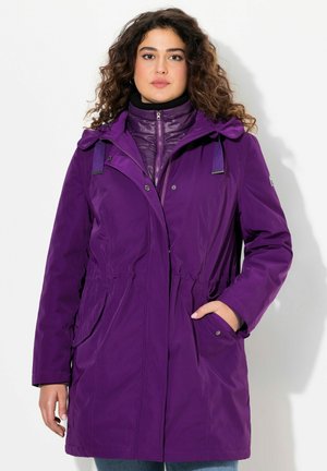 Paarse waterdichte buitenjas met een getailleerde taille, grote voorzakken en een afneembare capuchon, gelaagd over een geweven paarse binnenjas.