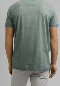 Groene ronde hals t-shirt met korte mouwen, met een gemêleerde textuur en rechte zoom. Zichtbare stiknaad bij de halslijn en mouwen.