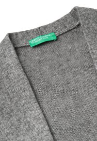 Šedý pletený cardigan s čistým designem. Má kulatý výstřih, jemnou strukturu a zelenou nálepku s nápisem "United Colors of Benetton."