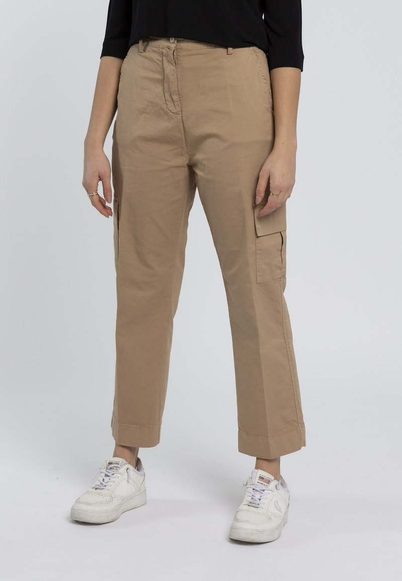 Pantaloni cargo color khaki in tessuto leggero, con tasche laterali, design a gamba dritta e vestibilità slim alle caviglie. Indossati con sneakers bianche.